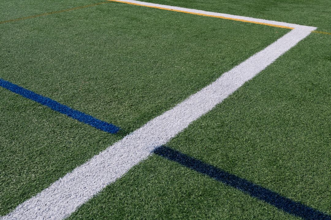 Close-up Artificial Turf Lines Crossing White Blue Yellow on Multi-sport Athletic Field