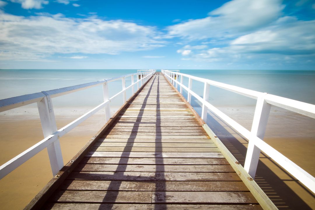 Wooden Pier Stretching into Horizon Over Calm Blue Sea - Free Images, Stock Photos and Pictures on Pikwizard.com