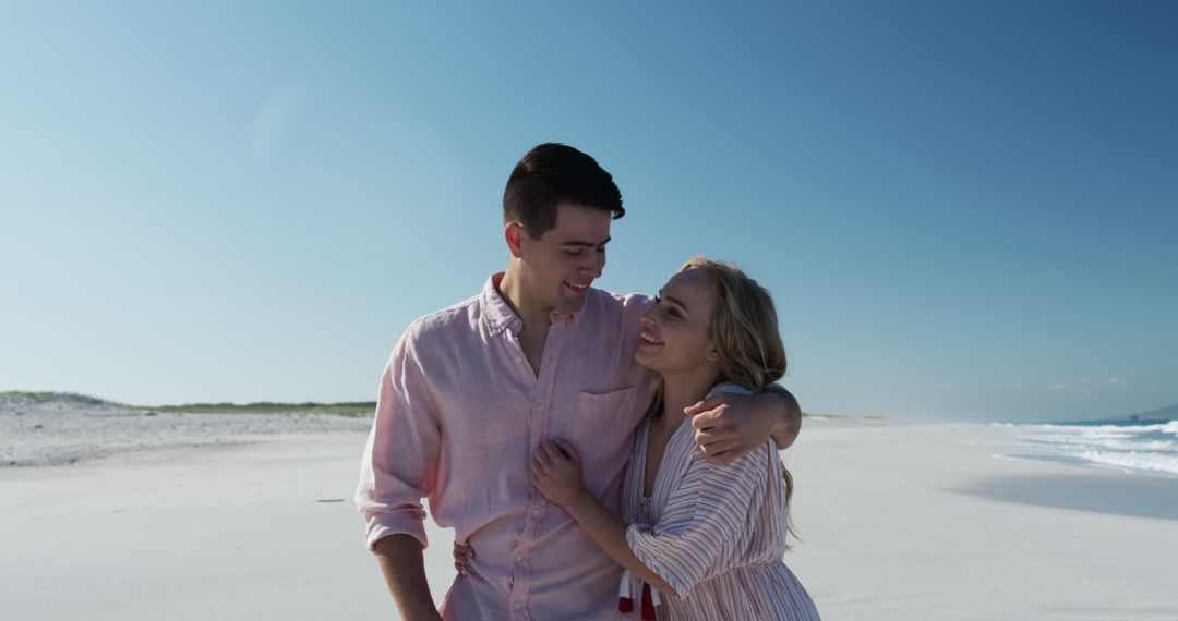 Young Couple Embracing on Sunny Beach - Free Images, Stock Photos and Pictures on Pikwizard.com