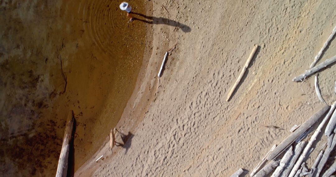 Person Standing at Edge of Dried Lake with Hat Casting Shadow - Free Images, Stock Photos and Pictures on Pikwizard.com