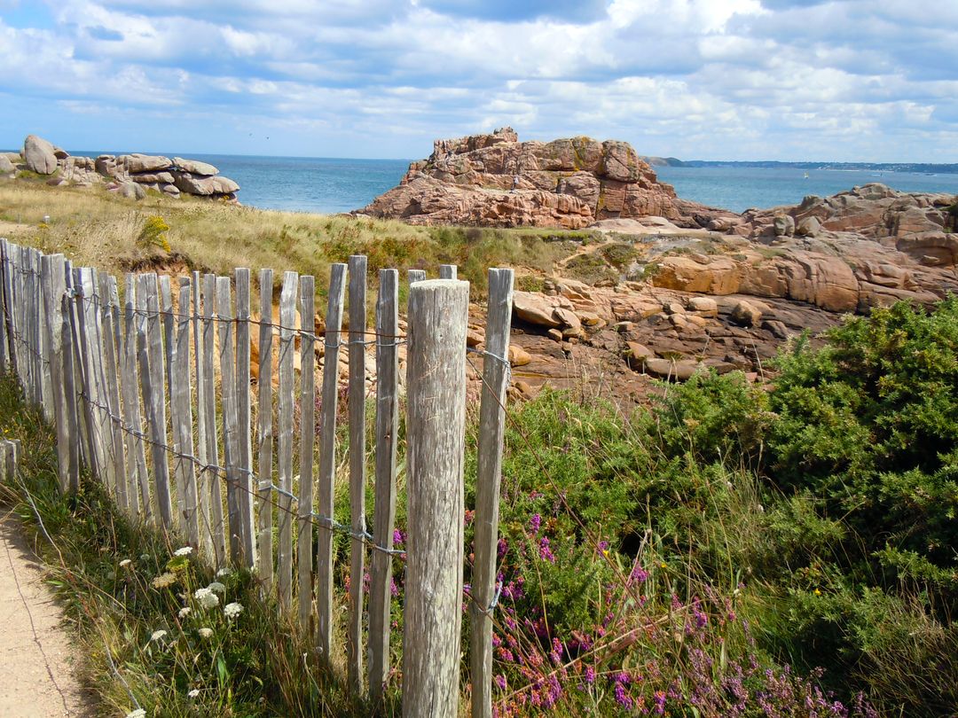 Rugged Coastal Path with Wooden Fence Along Rocky Shoreline - Free Images, Stock Photos and Pictures on Pikwizard.com