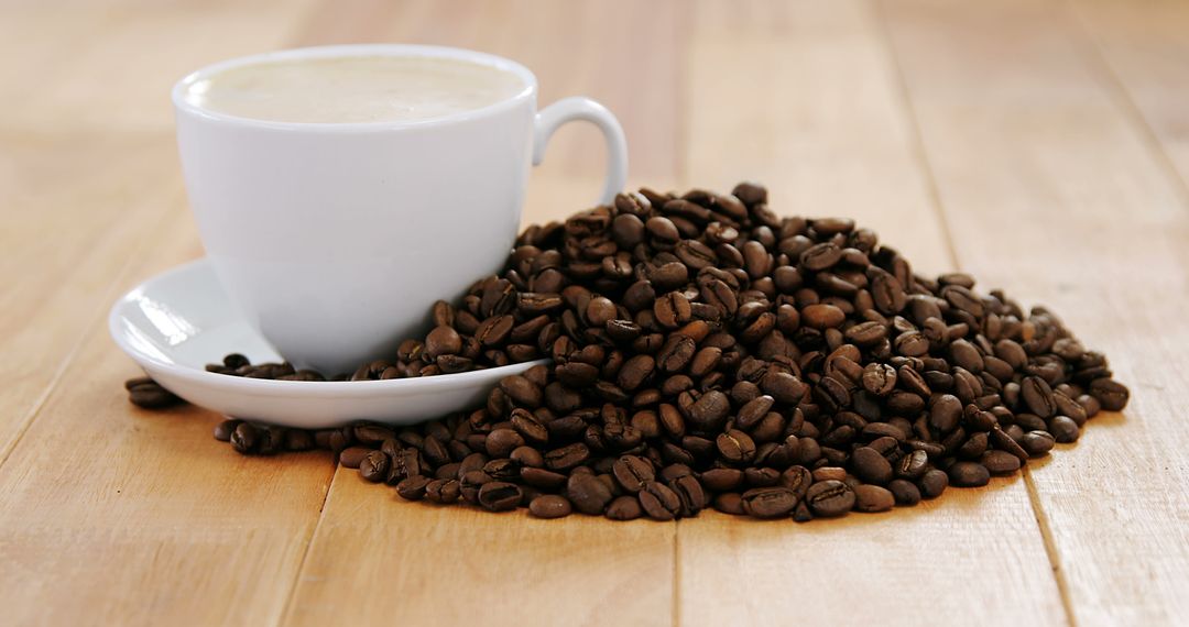 Cup of Cappuccino with Coffee Beans on Wooden Table - Free Images, Stock Photos and Pictures on Pikwizard.com