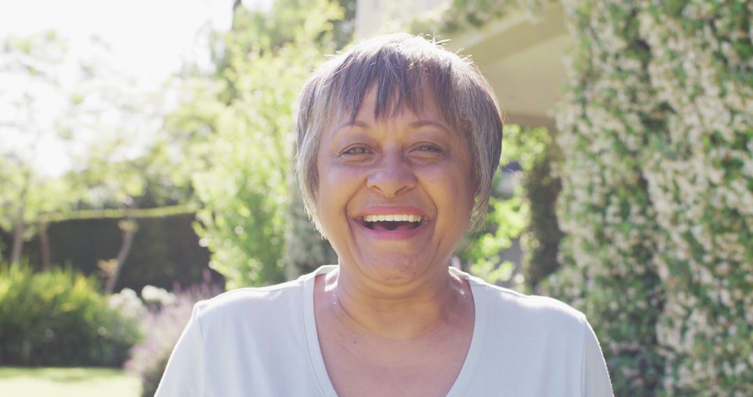 Joyful Elderly Woman Smiling Outdoors in Bright Sunlight - Free Images, Stock Photos and Pictures on Pikwizard.com