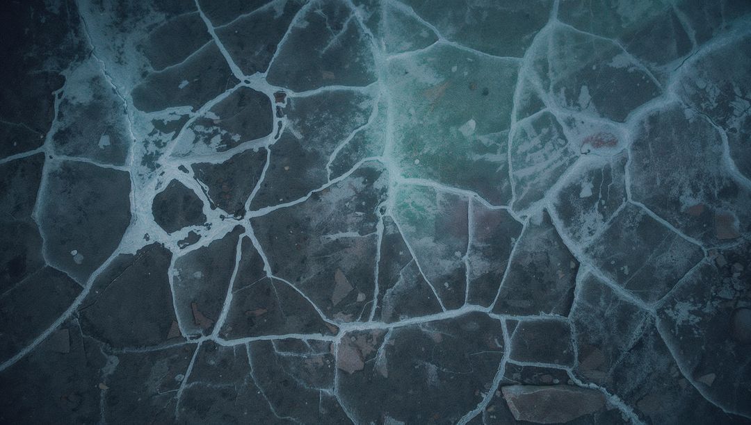 Displaying Cracked Frozen Lake Ice Aerial with Frost Seams and Polygonal Fracture Network