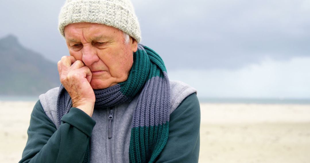 Senior Man Reflecting on Beach in Cold Weather - Free Images, Stock Photos and Pictures on Pikwizard.com