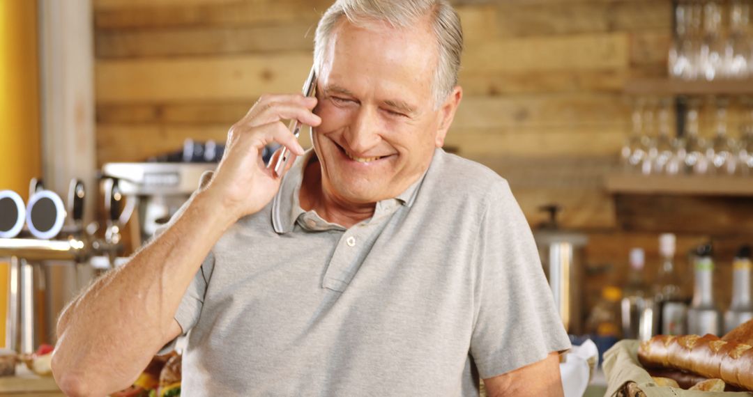 Senior man on call smiling in cozy cafe - Free Images, Stock Photos and Pictures on Pikwizard.com