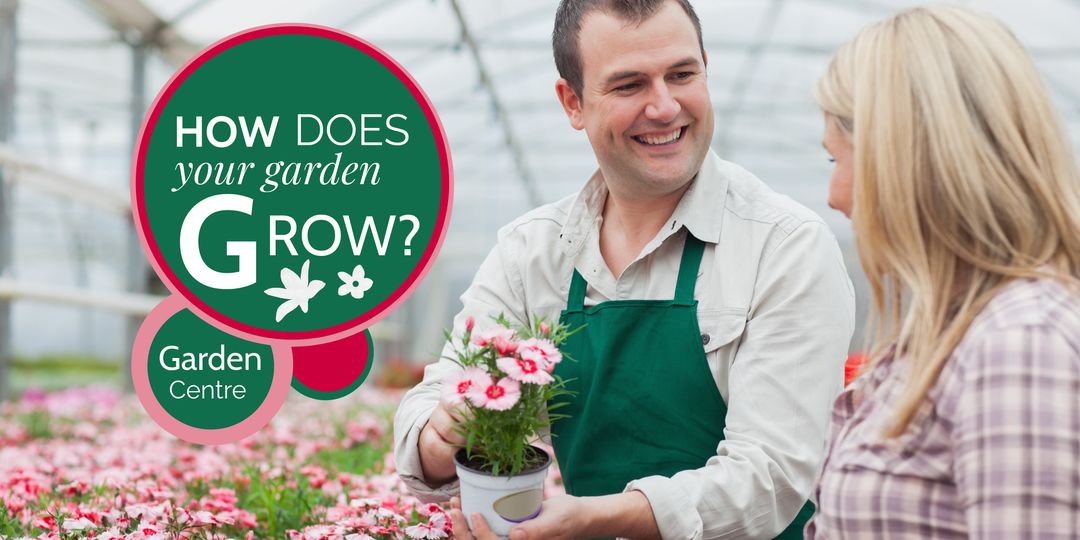 Friendly Gardener Assisting Customer in Vibrant Greenhouse