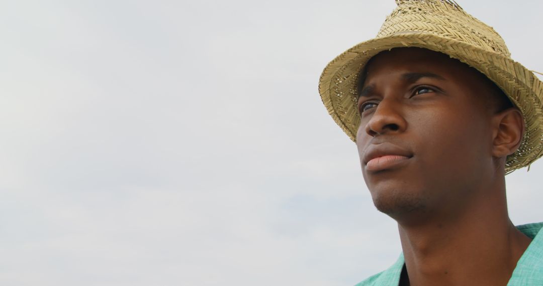 Contemplative Man in Straw Hat Enjoying Beach Day