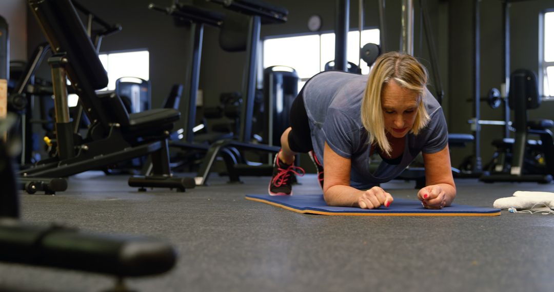 Mature Woman Exercising with Plank in Modern Gym - Free Images, Stock Photos and Pictures on Pikwizard.com