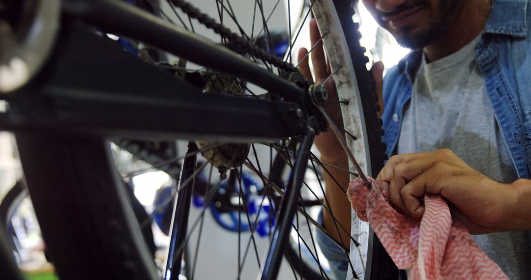 Mechanic Cleaning Bicycle Spoke in Workshop Setting