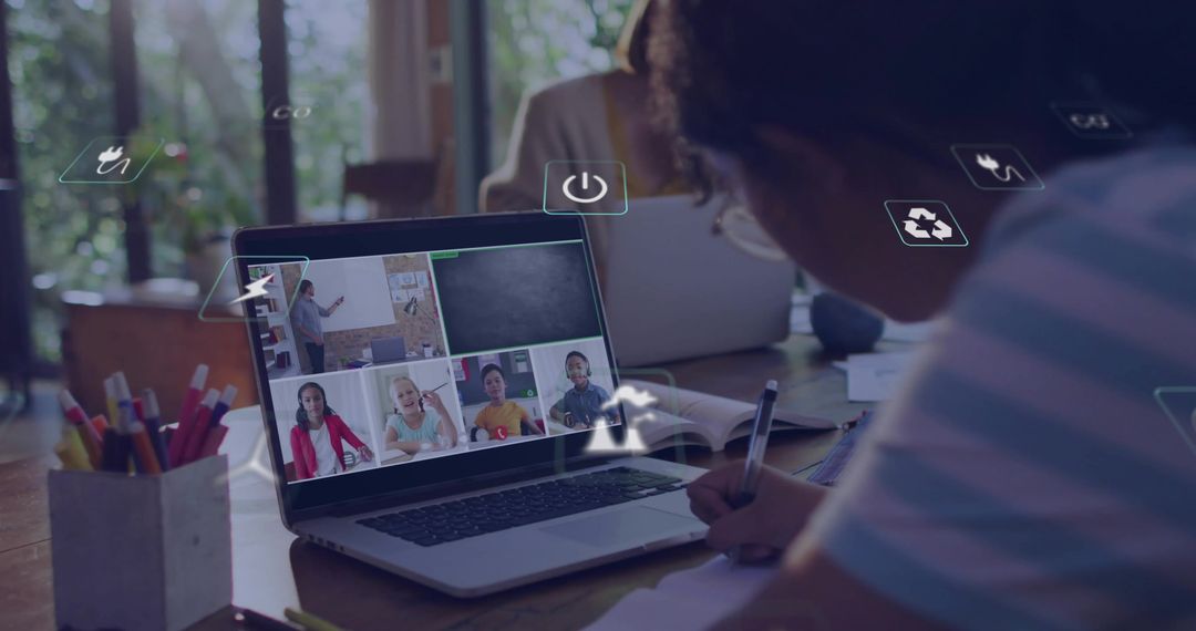 Writing student taking notes during remote class on laptop with virtual classroom grid daylight