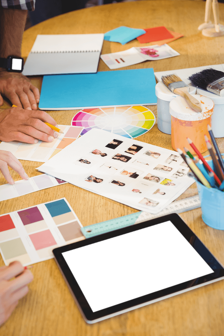 Creative projects on transparent desk: lively workspace with hands