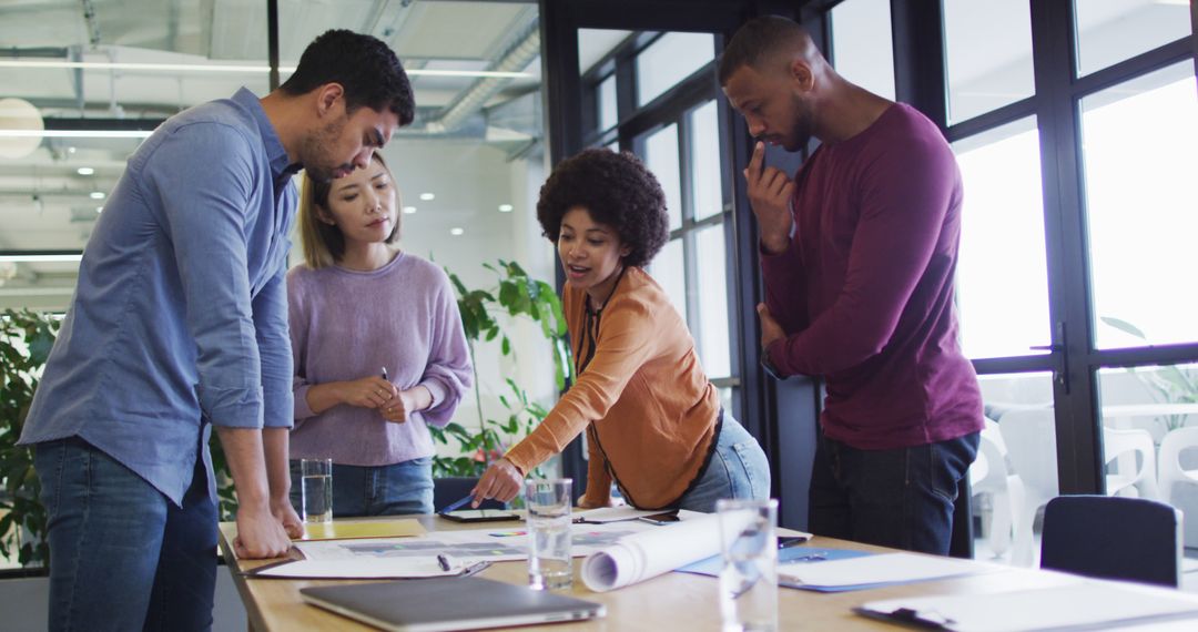 Diverse Team Collaborating on Office Blueprint for a New Project