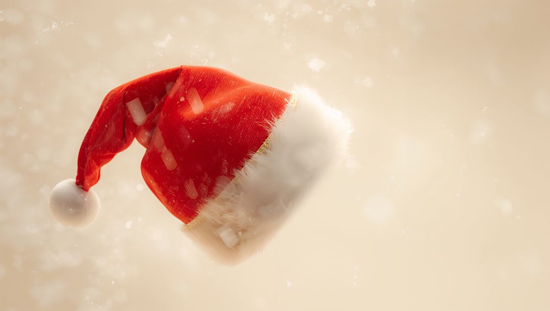 Floating red Santa hat with white fur trim and pompom on soft beige bokeh background festive