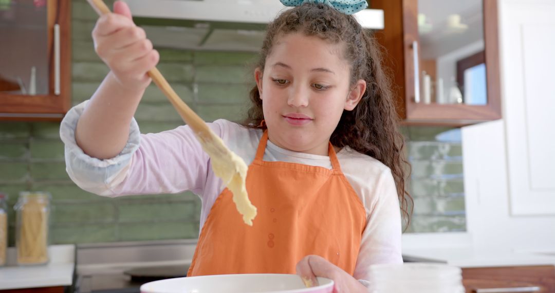 Young Girl Baking in Kitchen with Orange Apron - Free Images, Stock Photos and Pictures on Pikwizard.com