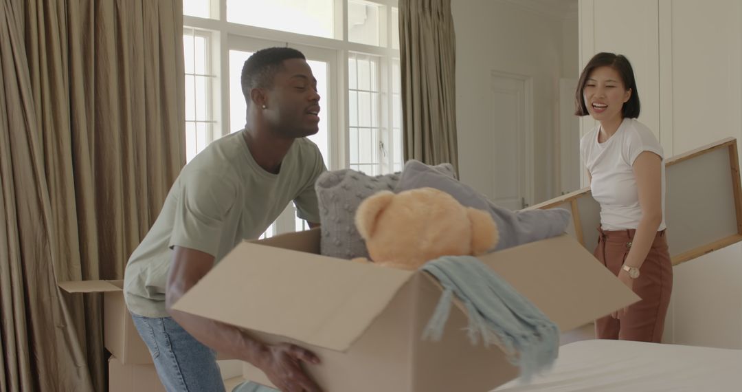Couple Unpacking Boxes Together in New Home with Smiles