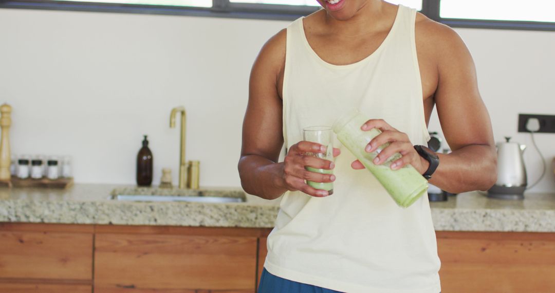 Man Pouring Green Smoothie in Kitchen for Healthy Lifestyle - Free Images, Stock Photos and Pictures on Pikwizard.com