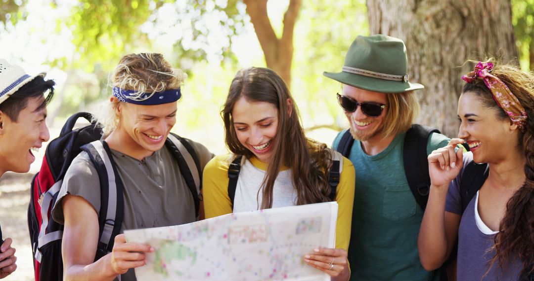 Happy young adults exploring with map on adventure