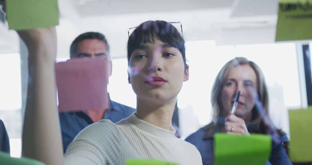 Team Collaborating on Innovative Project with Glass Board