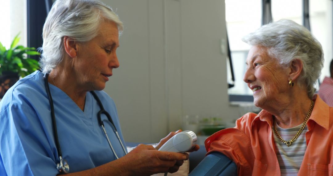 Senior Woman Smiling During Blood Pressure Check by Nurse - Free Images, Stock Photos and Pictures on Pikwizard.com