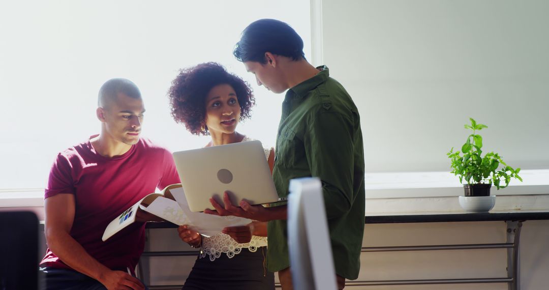 Diverse young professionals conduct team meeting with laptop