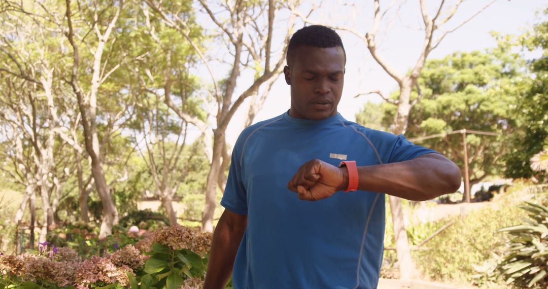 Man in Blue Sportswear Using Smartwatch in Nature Park - Free Images, Stock Photos and Pictures on Pikwizard.com