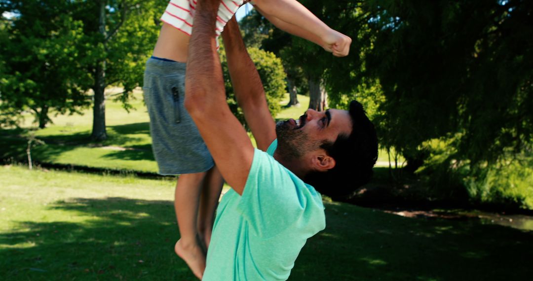 Father Lifting Son Outdoors in Park on Sunny Day - Free Images, Stock Photos and Pictures on Pikwizard.com