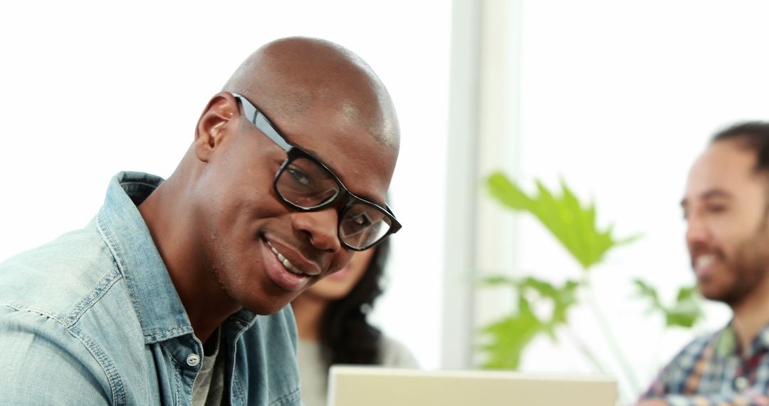 Smiling Man Wearing Glasses in Office Meeting - Free Images, Stock Photos and Pictures on Pikwizard.com