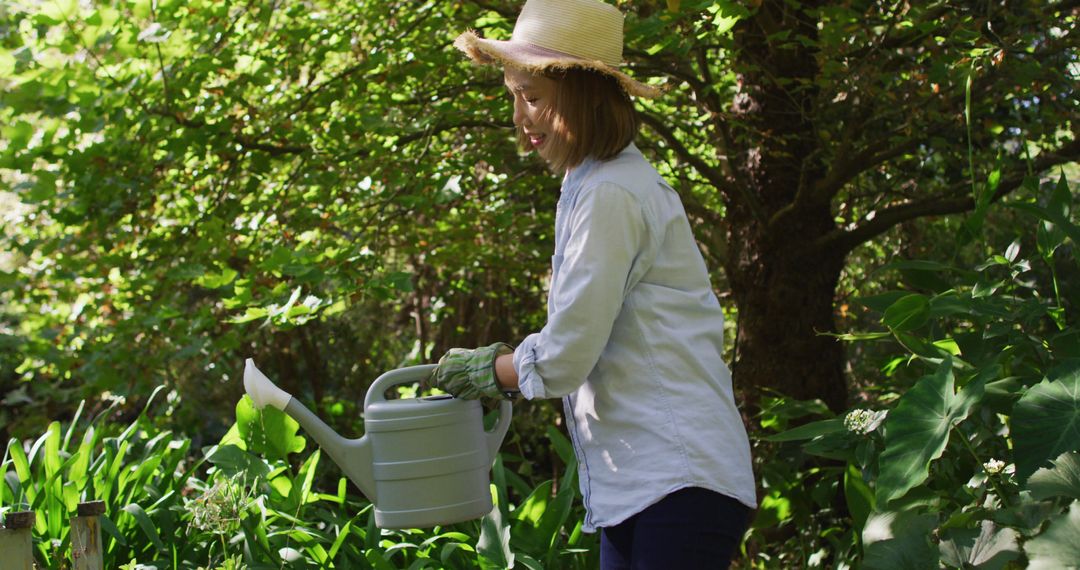 Woman Watering Plants in Lush Garden - Free Images, Stock Photos and Pictures on Pikwizard.com