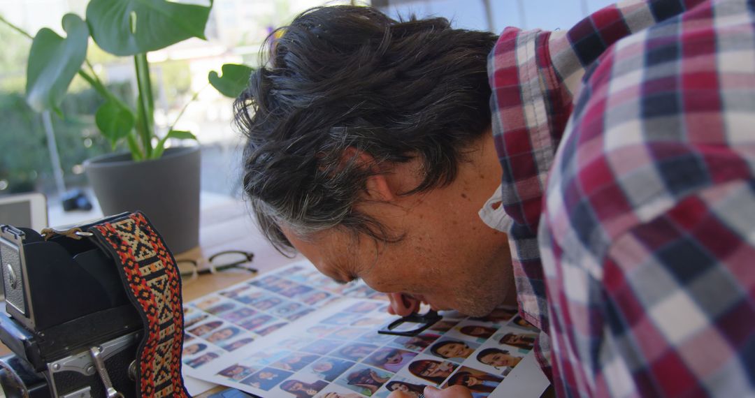 Man Using Magnifying Glass to Examine Photos - Free Images, Stock Photos and Pictures on Pikwizard.com