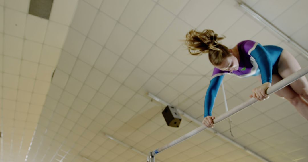 Female Gymnast Performing on Uneven Bars in Indoor Gym - Free Images, Stock Photos and Pictures on Pikwizard.com