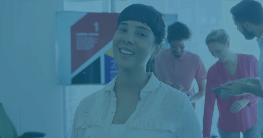 Confident professional smiling at camera during team meeting with digital screen