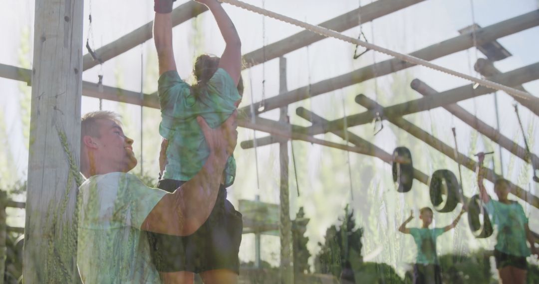 Father Supporting Daughter on Outdoor Adventure Challenge Course