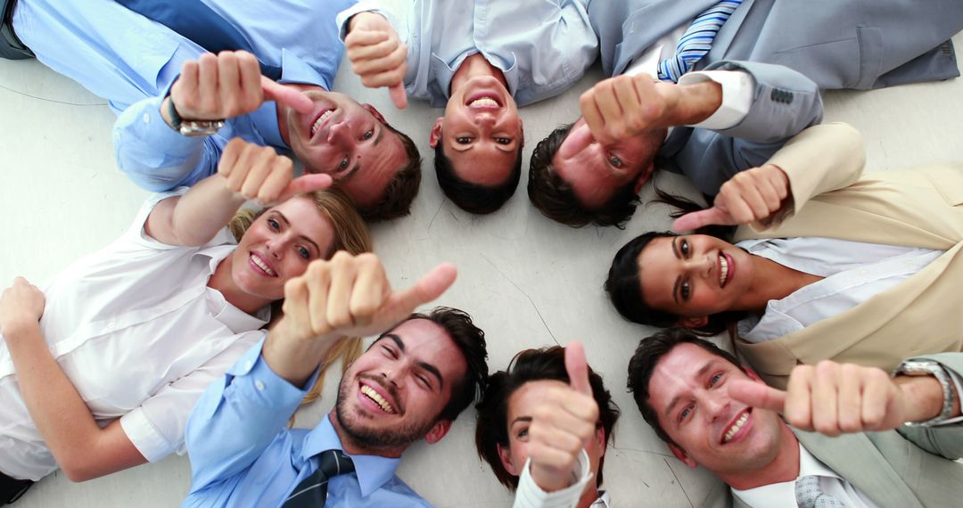 Successful business team lying in a circle giving thumbs up - Free Images, Stock Photos and Pictures on Pikwizard.com