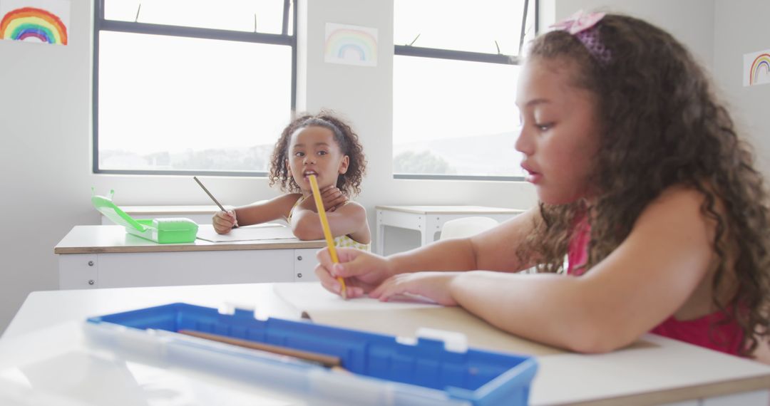 Two Young Girls Drawing in Classroom with Natural Light - Free Images, Stock Photos and Pictures on Pikwizard.com