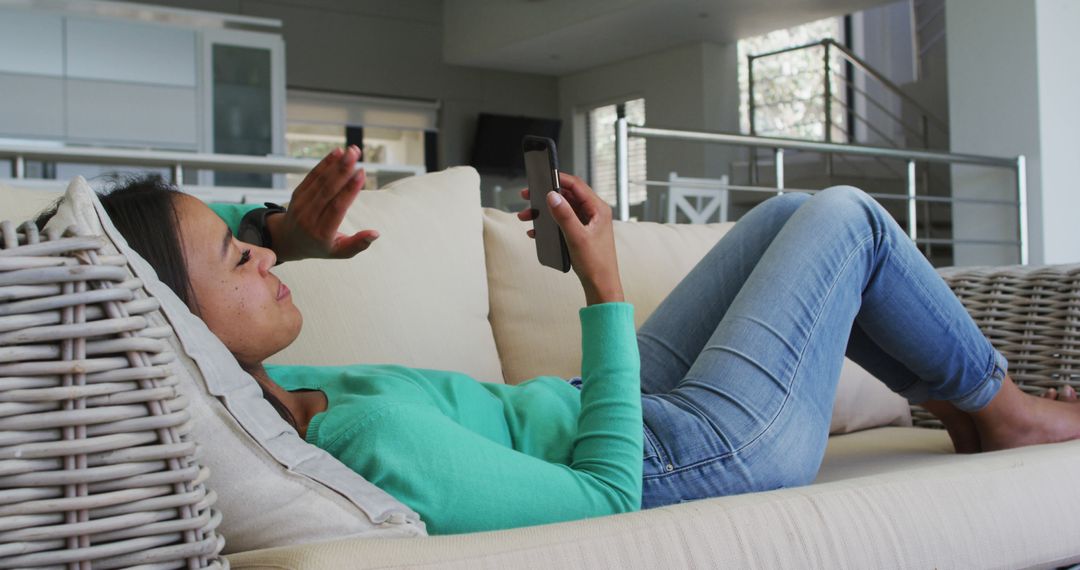 Young Woman Relaxing on Sofa Using Smartphone at Home - Free Images, Stock Photos and Pictures on Pikwizard.com