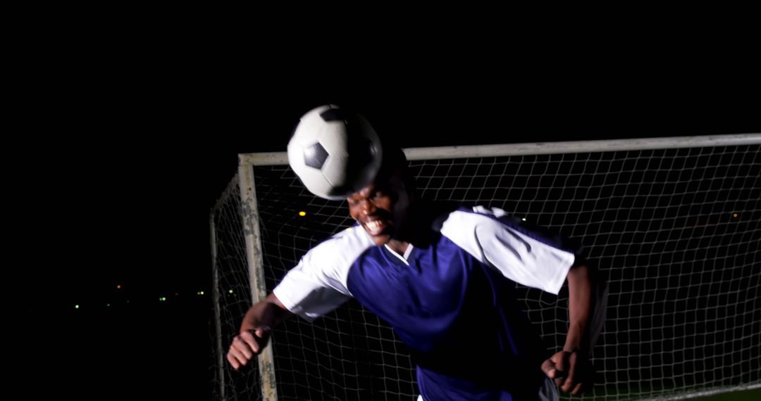 Male Soccer Player Heading Ball During Night Game - Free Images, Stock Photos and Pictures on Pikwizard.com