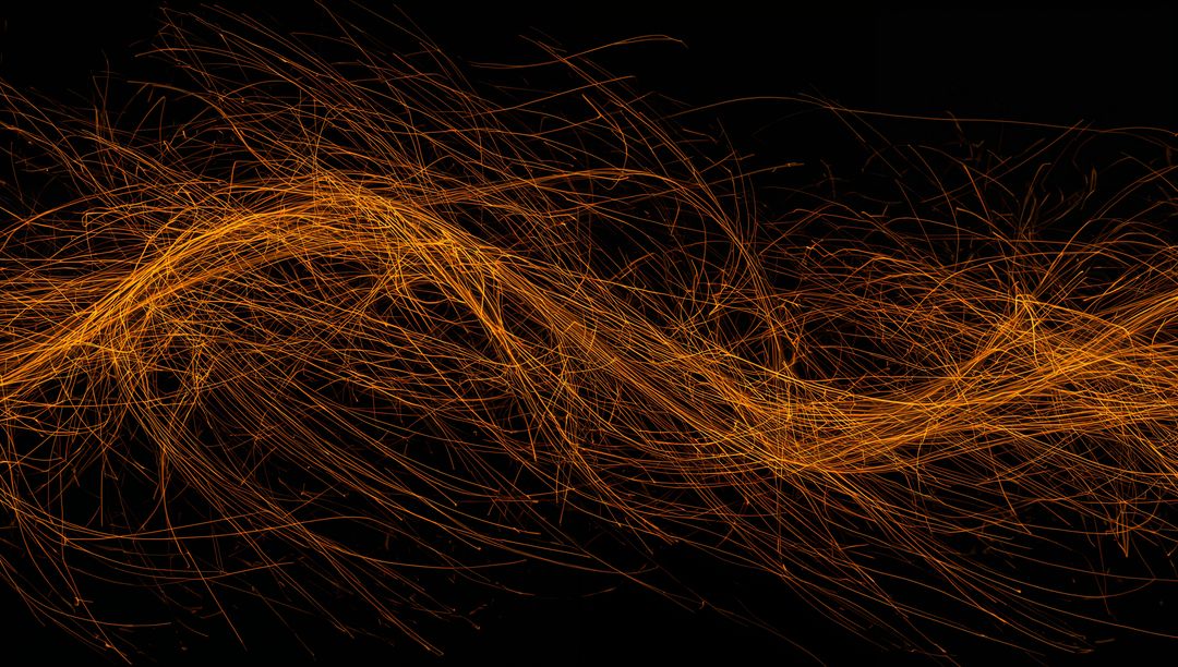 Flowing Orange-Gold Light Trails Creating Dynamic Wave of Sparks Across Black Canvas