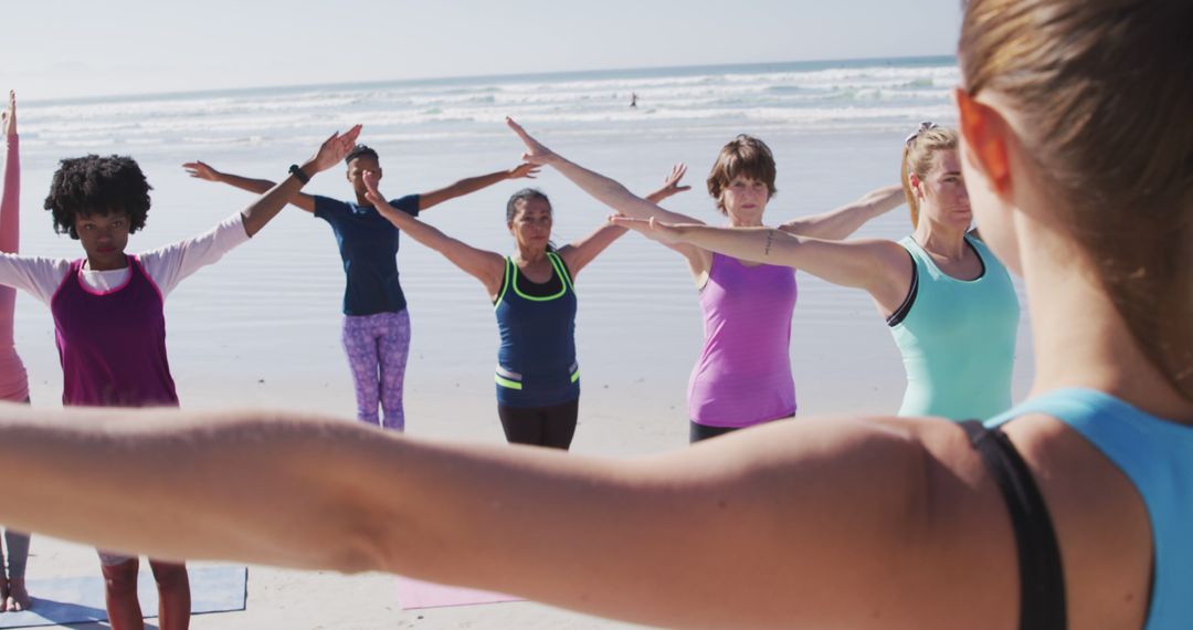 Group of Women Practicing Yoga on Beach, Arms Outstretched - Free Images, Stock Photos and Pictures on Pikwizard.com