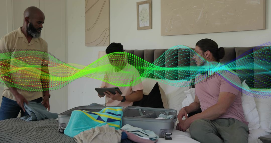 Group Packing on Bed Using Tablet for Trip Planning with Open Suitcase and Digital Wave