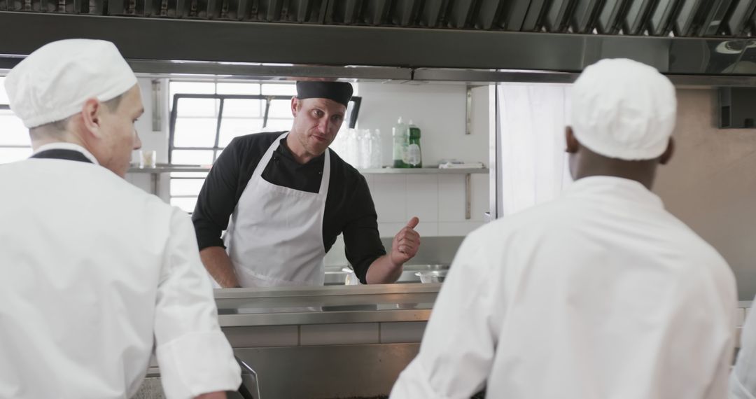 Chef giving instructions to kitchen staff in commercial kitchen - Free Images, Stock Photos and Pictures on Pikwizard.com