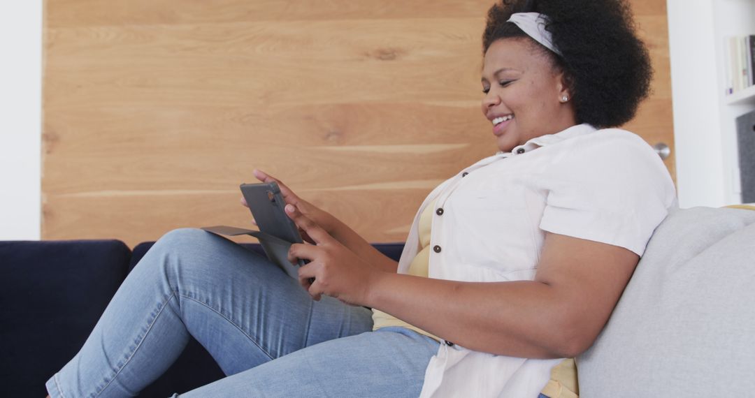 Happy Biracial Plus Size Woman Relaxing with Tablet at Home
