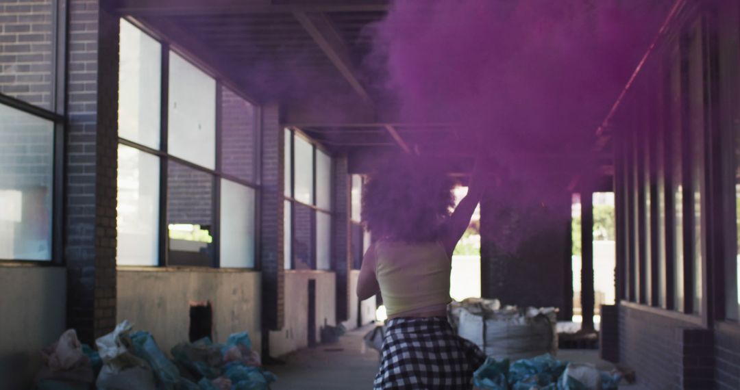 Woman Holding Purple Smoke Bomb in Abandoned Industrial Building - Free Images, Stock Photos and Pictures on Pikwizard.com