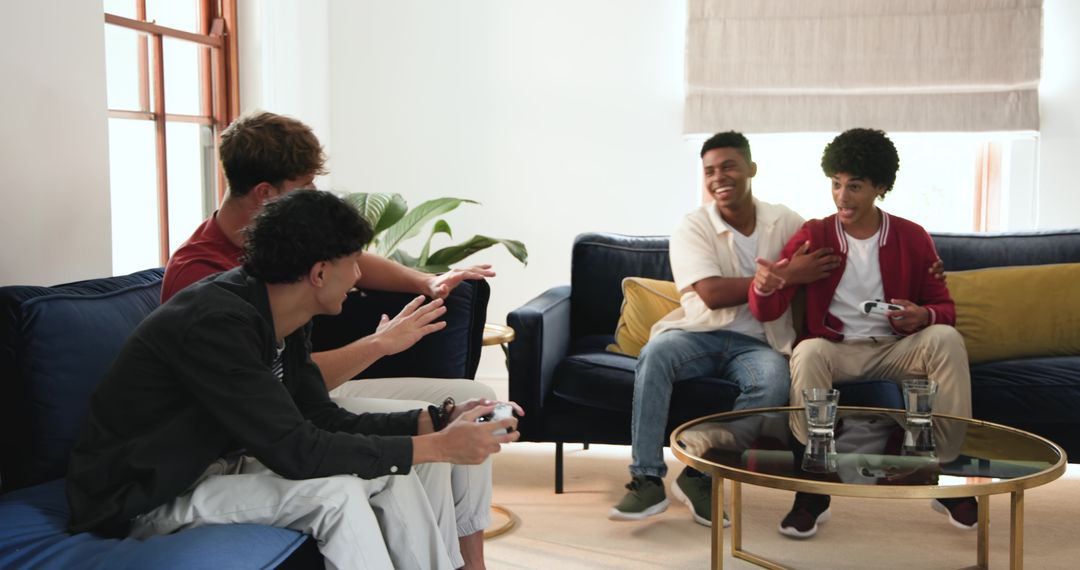 Diverse young men playing console games on blue sofas in modern living room
