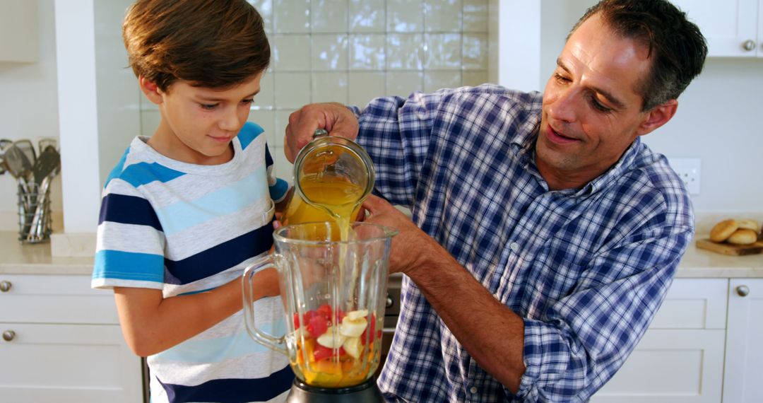 Father and Son Preparing Fruit Smoothie Together in Home Kitchen - Free Images, Stock Photos and Pictures on Pikwizard.com