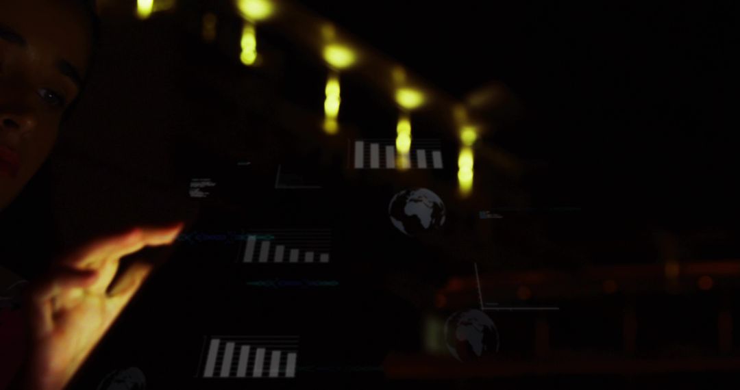 Reaching hand touching holographic data interface in dim lab, globe and bar charts