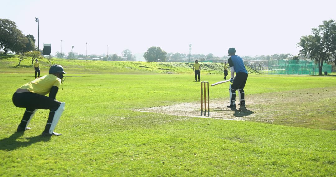 Diverse Team of Cricketers Engaged in Exciting Match on Lush Green Field