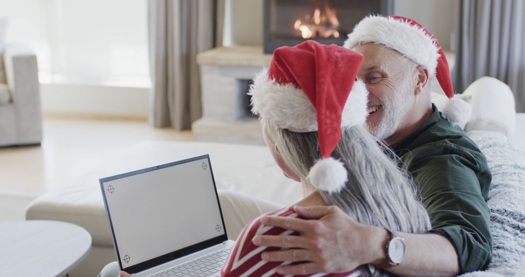 Senior Couple Enjoying Christmas Together with Laptop by Fireplace - Free Images, Stock Photos and Pictures on Pikwizard.com