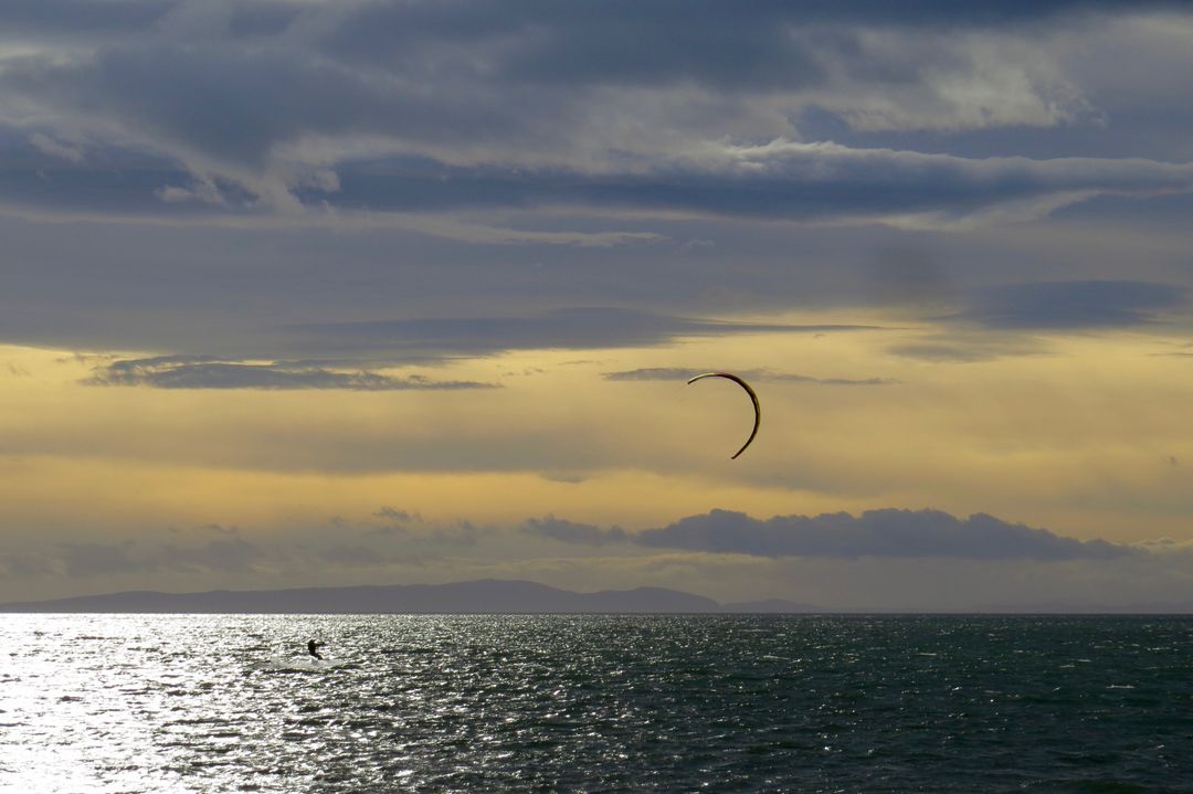 Kitesurfer Enjoying Sunset on Calm Ocean - Free Images, Stock Photos and Pictures on Pikwizard.com