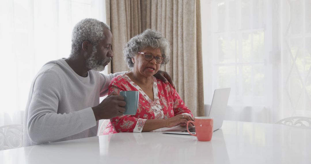 Senior Couple Using Laptop at Home with Coffee Cups - Free Images, Stock Photos and Pictures on Pikwizard.com